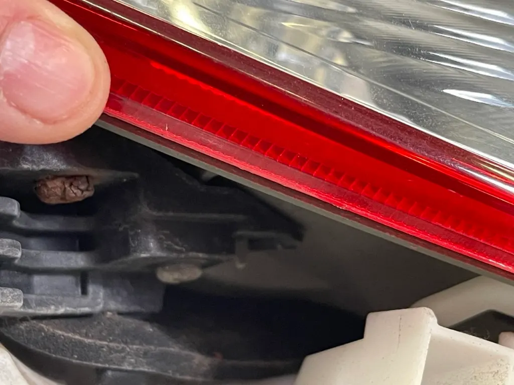 Detailprüfung einer Rückleuchte auf versteckte Schäden